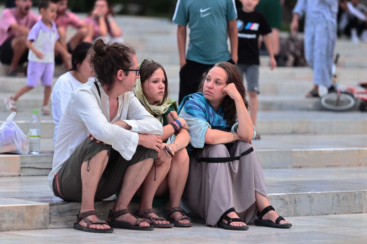Short rest during the sightseeing program Travelers taking a short rest on stone steps during a sightseeing day