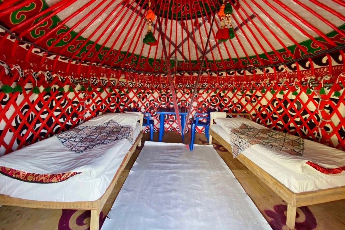 Betten in einer Jurte mit rotem Holzgerüst — Tulpar CBT Yurt Camp