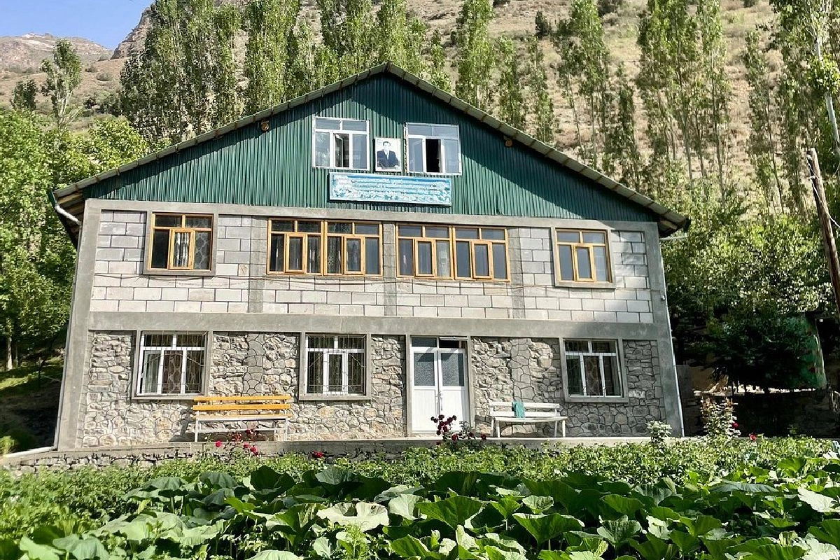 Maison d’hôtes à deux étages au toit vert dans la vallée de Ching