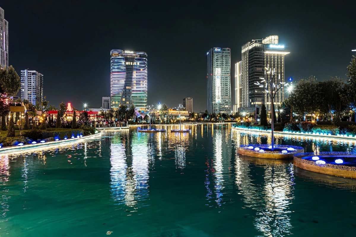 Tashkent City at night with illuminated buildings and water reflections