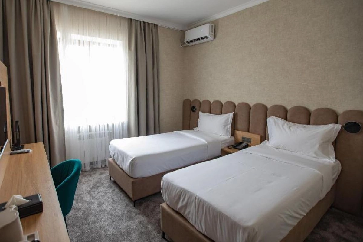 Zwei Betten mit gepolsterten Kopfteilen, Blick vom Eingang — Kaganat Boutique Hotel