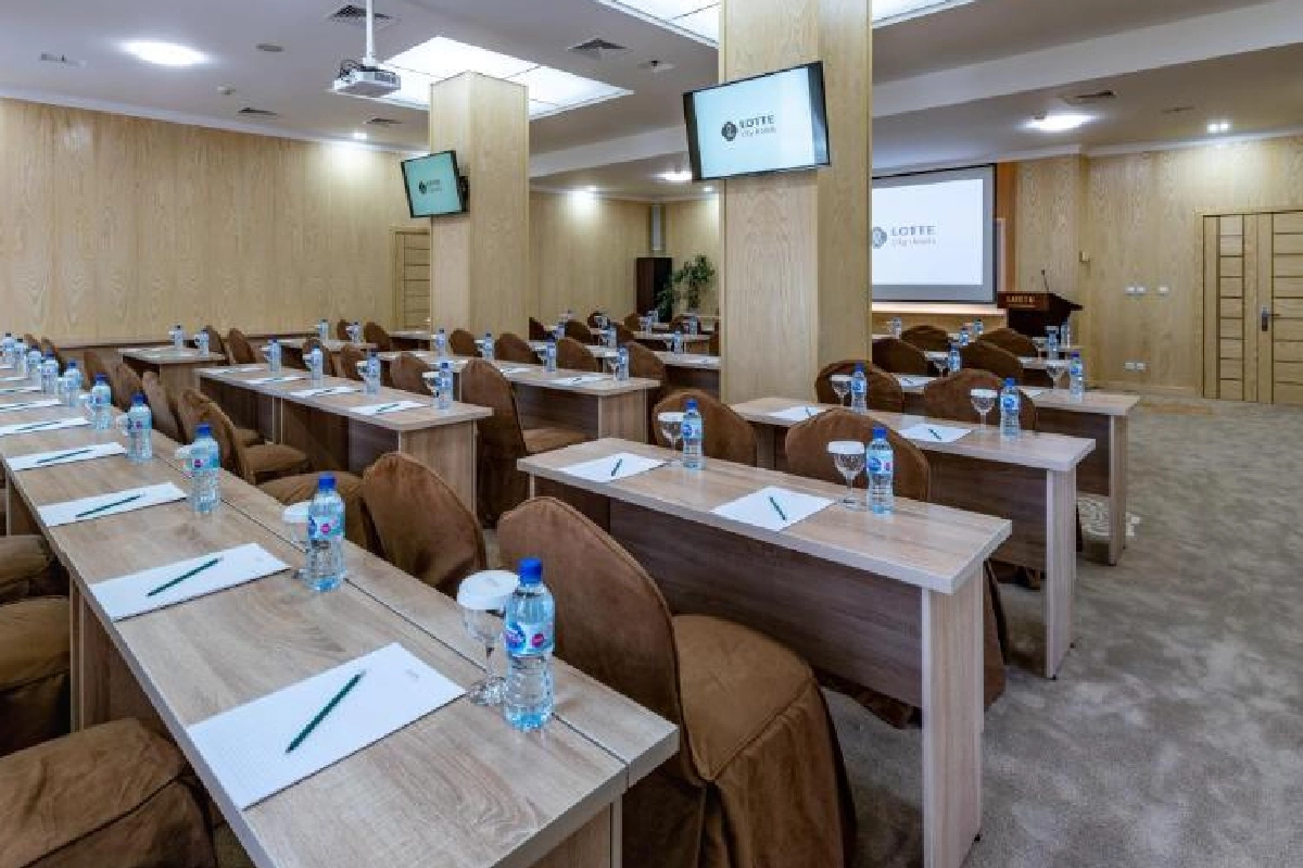 Salle de conférence du Lotte Tashkent City Palace avec disposition en classe, écrans et projecteur