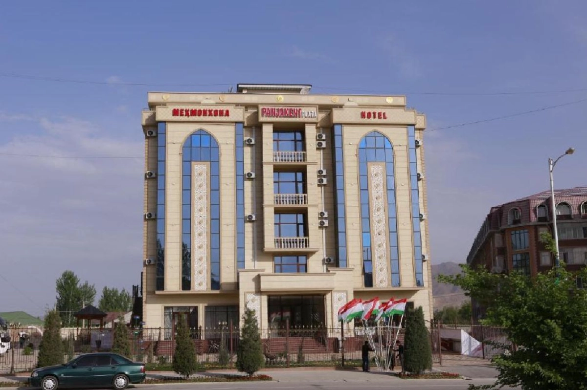 Фасад Panjakent Plaza Hotel в Пенджикенте с вывеской и флагами Таджикистана