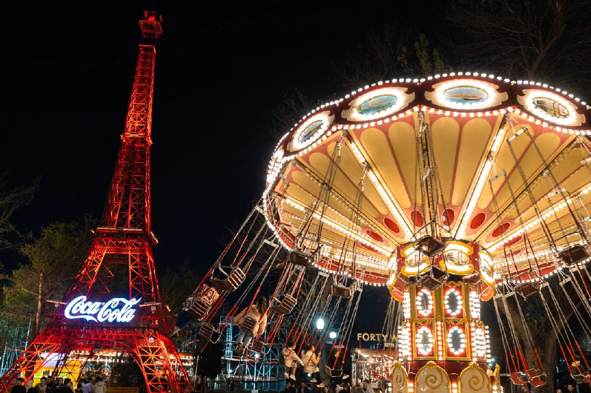 Illuminated tower and evening amusement ride in Tashkent