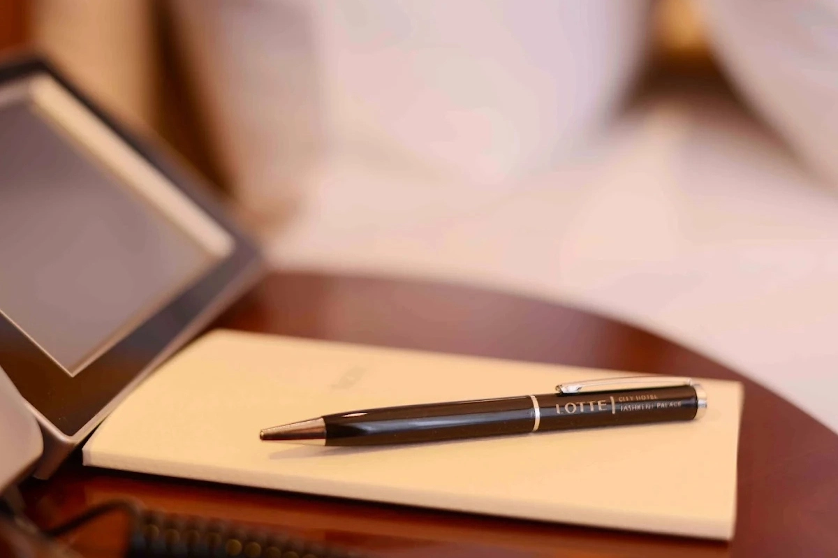 Papeterie Lotte Tashkent City Palace pour événement professionnel Bloc-notes et stylo Lotte Tashkent City Palace sur une table de travail