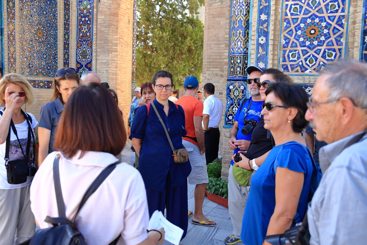 Guided explanation beside a blue tiled wall Guide explaining details to a travel group near a blue tiled wall