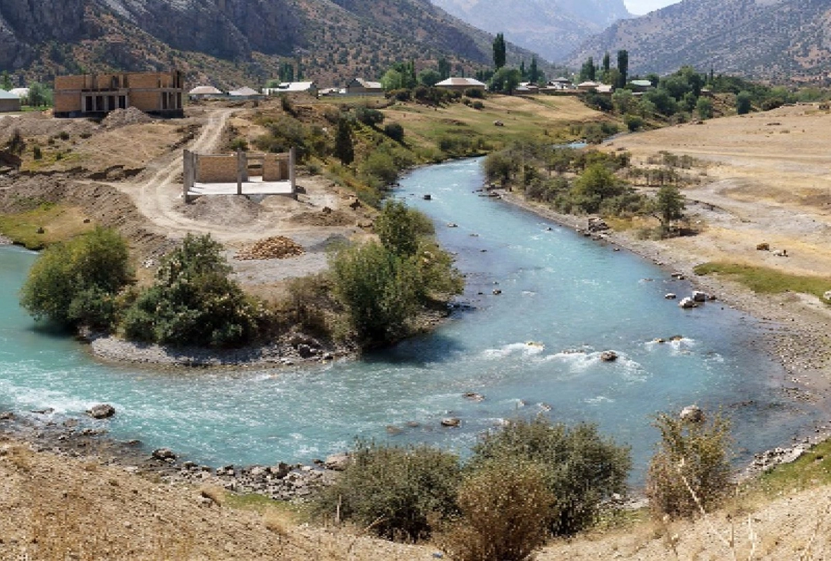 İskenderkul yolundaki dağ vadisi Tacikistan’da dağ yamaçları ve köyler arasında turkuaz nehir