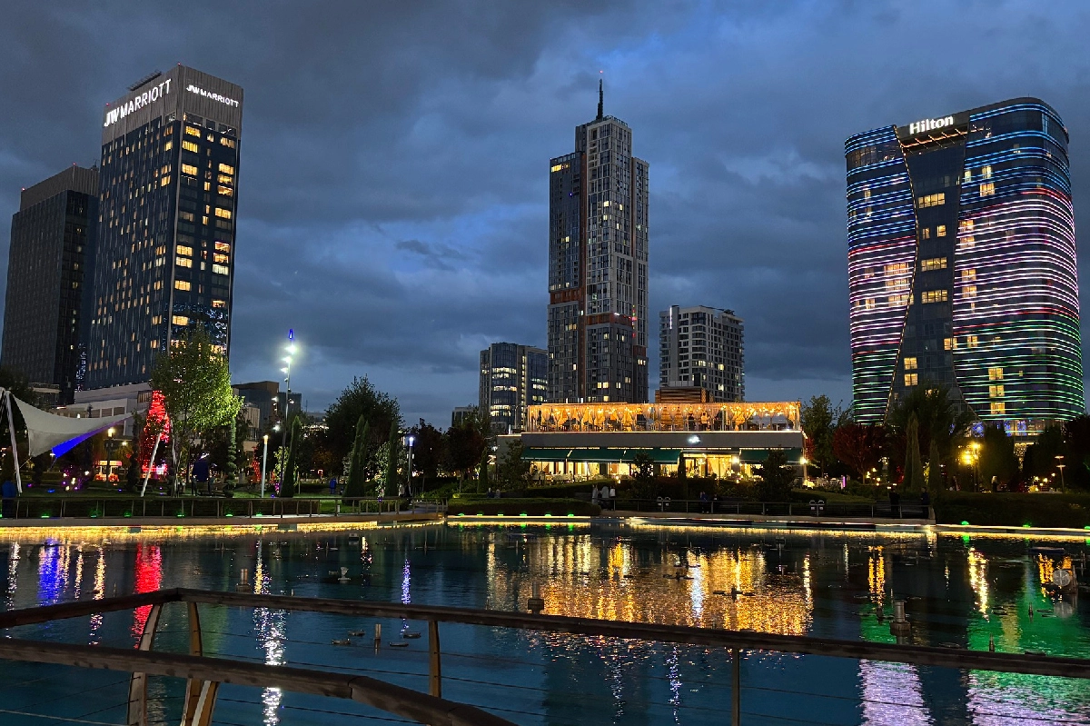 Tashkent City skyscrapers reflected in water at sunset