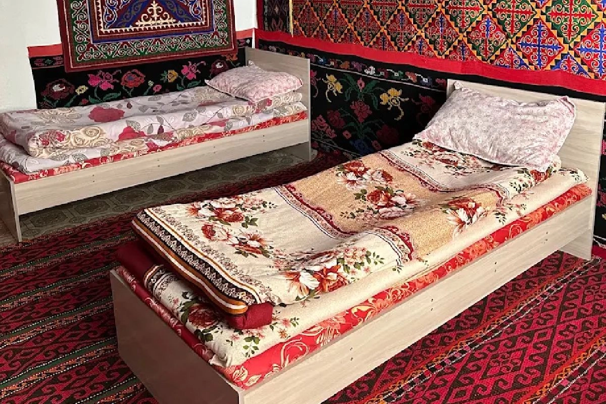 Zwei Holzbetten und Wandteppiche — Erali Guesthouse