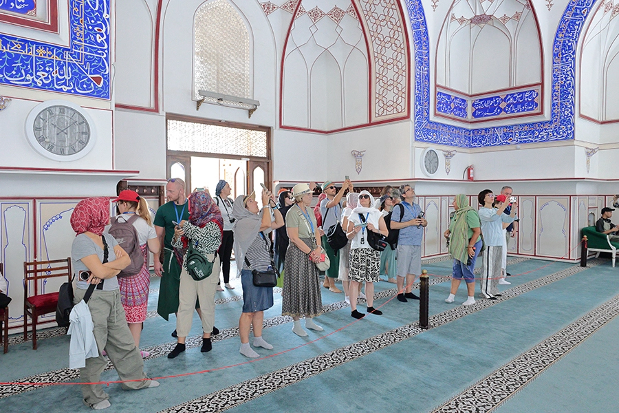 US tourist group inside the Bolo Hauz Mosque in Bukhara during a tour to Uzbekistan