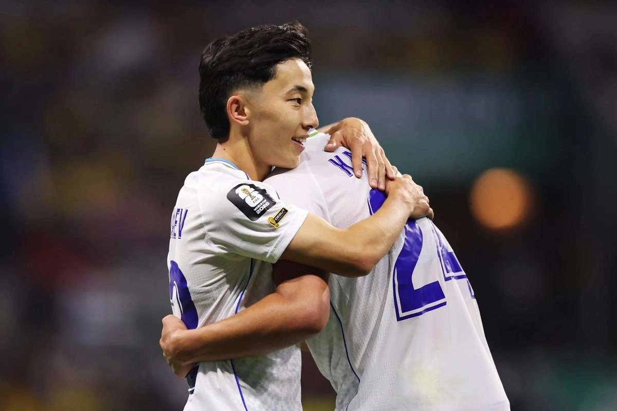 Two Uzbekistan football players embracing after a match moment