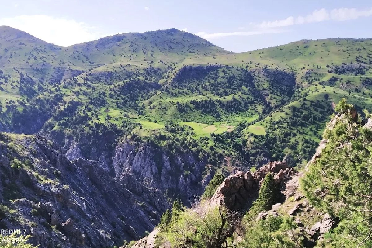 Felsige Schlucht und grüne Hänge im Geologischen Nationalpark Kitab
