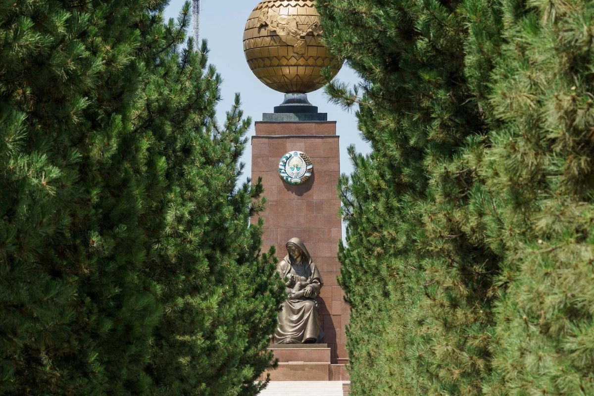 The Monument of Independence and Humanism in Tashkent: a globe and a sculpture of a mother and child among trees