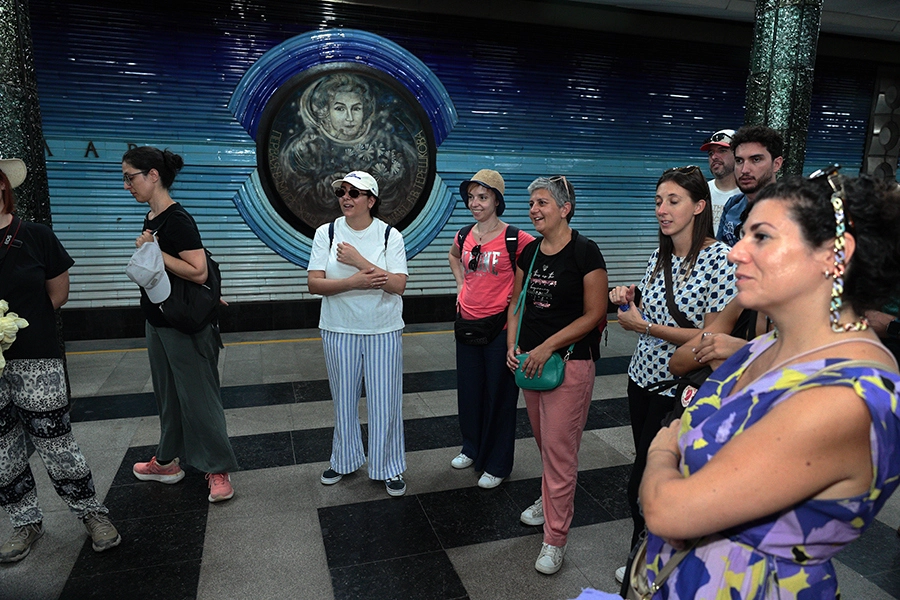 Tour group delighted by guide's stories inside the beautiful Kosmonavtov Metro Station, Tashkent