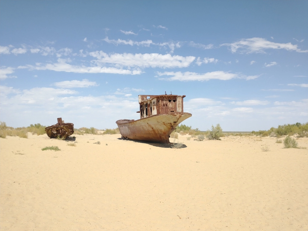 Fishing boat on the former seabed in Muynak Rusted fishing boat on sandy former seabed at Muynak Ship Cemetery