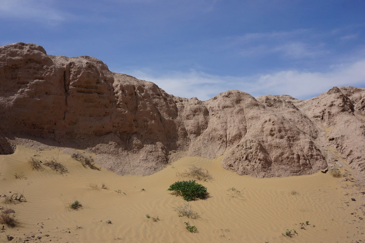 Sand beside an ancient fortress wall Windblown sand at the base of an eroded mud-brick fortress wall